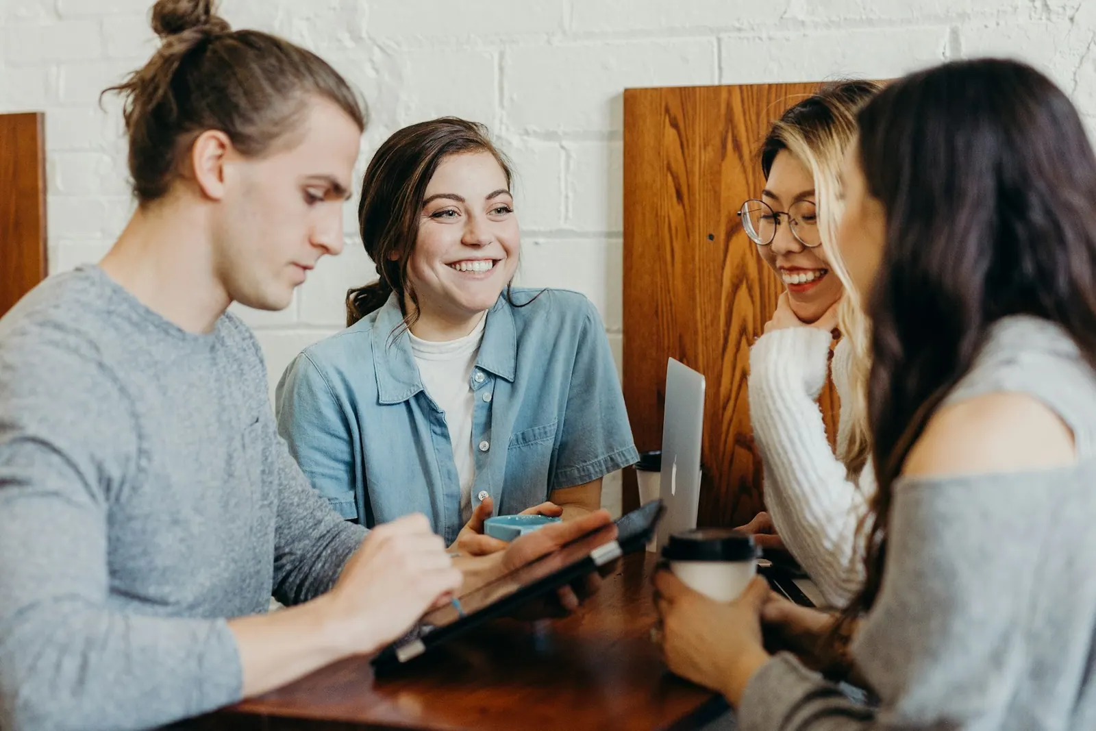 Personas reunidas tomando un café mientras se guardan notas y contactos