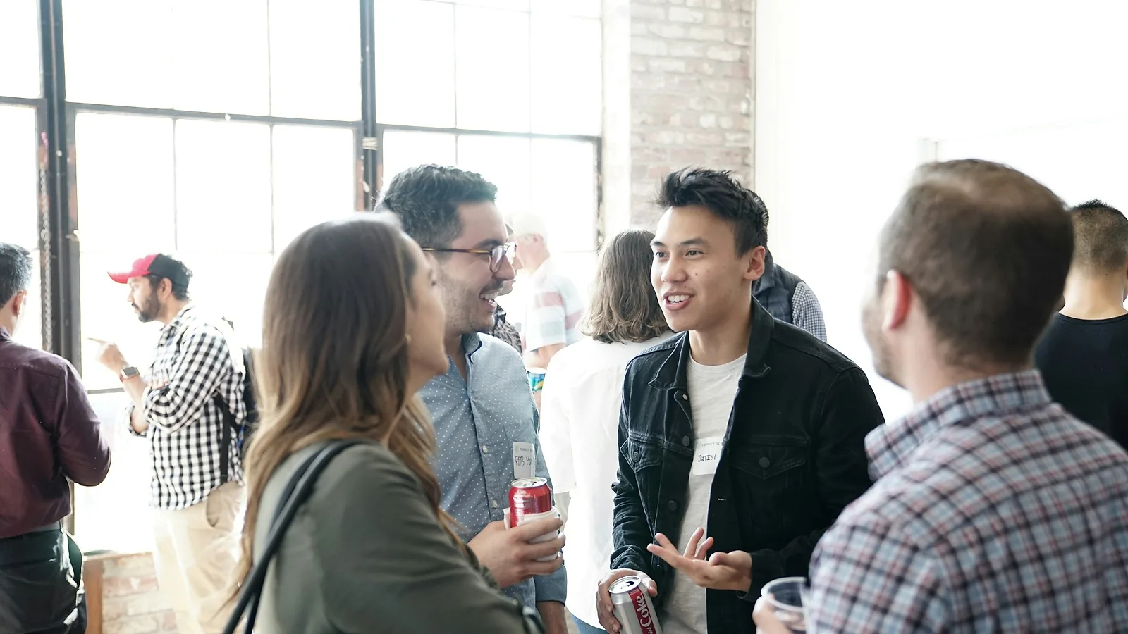 People talking at a networking event wearing name badges, the moment details get exchanged